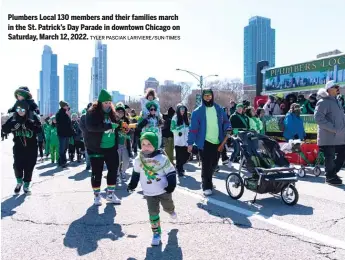  ?? TYLER PASCIAK LARIVIERE/SUN-TIMES ?? Plumbers Local 130 members and their families march in the St. Patrick’s Day Parade in downtown Chicago on Saturday, March 12, 2022.