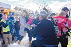  ?? RYAN REMIORZ/THE CANADIAN PRESS VIA AP ?? Parents and their children are loaded onto a warming bus as they wait for news after a bus crashed into a day care center in Laval, Quebec, on Wednesday.