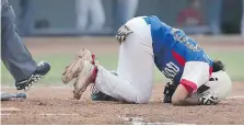  ?? DAN JANISSE ?? Team Quebec’s Marie-France Castillo hit the dirt in pain after fouling a ball off her knee.