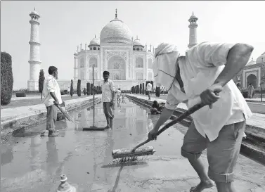  ?? SAUMYA KHANDELWAL / REUTERS ?? Laborers clean the fountain in the historic Taj Mahal premises in Agra, India, on Saturday.