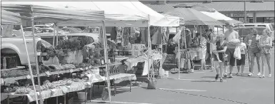  ?? Keith Bryant/The Weekly Vista ?? A group of people walks along and looks at goods up for sale at last weekend’s Bella Vista Farmers market.