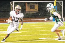  ?? SHARON K. MERKEL/SPECIAL TO THE MORNING CALL ?? Whitehall’s Damonte Foreman, left, runs the ball against Central Catholic on Saturday night at J. Birney Crum Stadium in Allentown. Central Catholic won 21-7.