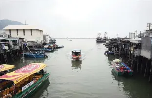  ??  ?? HONG KONG: A tour boat (center) returning after a trip to see the famous pink dolphins in the waters around Tai O.