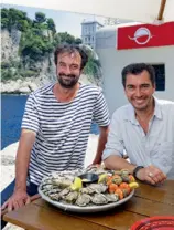  ??  ?? Le Malouin Frédéric Rouxeville et le Cannois Brice devant un plateau d’huîtres au port de Fontvieill­e.