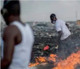  ??  ?? Young men burn e- waste ( left) and women sell water sachets ( right) at the Agbogblosh­ie dumpsite in Accra, Ghana