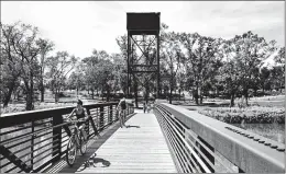  ?? JENN ACKERMAN | FOR THE WASHINGTON POST ?? BIKERS CROSS the Red River, which marks the border between Fargo and Moorhead. The waterway meanders 550 miles from Breckenrid­ge, Minn., up to Lake Winnipeg in Manitoba.