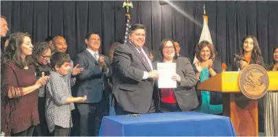  ?? TINA SFONDELES/SUN-TIMES ?? Gov. J.B. Pritzker signs legislatio­n that prohibits landlords from using citizenshi­p status to threaten tenants.