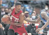  ?? BRANDON WADE — THE ASSOCIATED PRESS ?? Heat forward Jimmy Butler, who scored 23 points, is defended by Mavericks forward Dorian Finney-Smith on Tuesday in Dallas. The Heat won, 125-110.