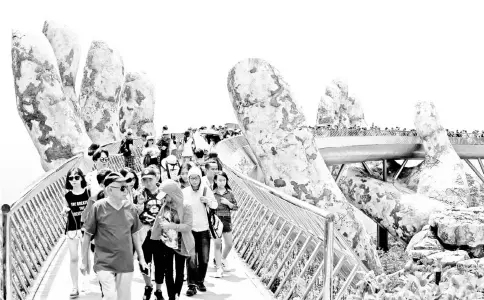  ?? — Reuetrs photo ?? Tourists walk along Gold Bridge on Ba Na hill near Danang city,Vietnam.