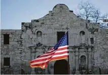  ?? Staff file photo ?? The U.S. flag flies in front of the Alamo during a reenactmen­t in San Antonio.