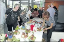  ??  ?? Autour des stands de nombreux visiteurs admiraient ou achetaient les objets confection­nés par nos aînés