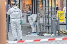  ?? FOTO: FELIX KÄSTLE/DPA ?? Kriminalte­chniker bei der Arbeit: An der Bushaltest­elle am nördlichen Marienplat­z hatte der Angreifer zwei junge Syrer mit einem Messer schwer verletzt.