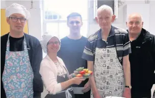  ??  ?? ●●Brad Gartland and Pete Duffy of the SG6 Foundation present a cheque to the Kitchen Kapers mental health cookery class