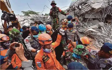  ?? AFP PIC ?? Members of a search-and-rescue team carrying the body of an earthquake victim in Bangsal, Lombok, yesterday.