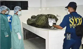  ??  ?? Grim task: Philippine National Police’s Scene of the Crime Operatives preparing to examine what they said was the remains of Kantner. — AP