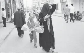  ?? FREDERIC J. BROWN/AFP/Getty Images files ?? A Uighur Muslim woman walks along a street in Kashgar. Authoritie­s in China’s restive western province of Xinjiang have reacted to a growing threat of separatist and Islamist
violence by banning women from wearing burkas in public in the region.