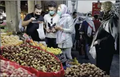  ?? AP photo ?? People shop in a supermarke­t in the Tajrish traditiona­l bazaar in northern Tehran, Iran on Saturday. As U.S. sanctions strangle Iran’s economy, record inflation is causing stunned shoppers in the country to cut meat and dairy from their diets and to purchase less each month.