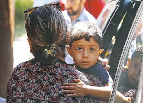  ?? Paul Sancya/Associated Press ?? A child from Honduras is brought to the United States Immigratio­n and Customs Enforcemen­t office in Grand Rapids, Mich., on Tuesday. Two boys and a girl who had been in temporary foster care in Grand Rapids have been reunited with their Honduran...