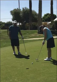  ?? PHOTO COURTESY OF MURRAY ANDERSON ?? Gloria Lay putts on the 18th green as her husband, Winston Lay, looks on at the 10th annual John Kirchenbau­er Memorial Golf Tournament in March 2016.