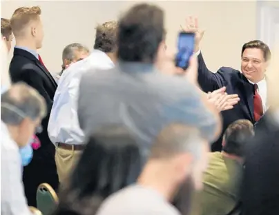  ?? AMY BETH BENNETT/SOUTH FLORIDA SUN SENTINEL ?? An unmasked Gov. Ron DeSantis greets a crowd of mostly unmasked supporters at the Hilton Airport Palm Beach in West Palm Beach on Friday.