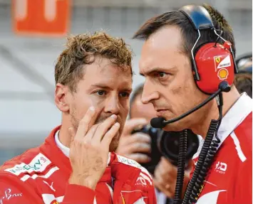  ?? Foto: Andrej Isakovic, afp ?? Ein starkes Team: Pilot Sebastian Vettel spricht mit einem Mitglied der Scuderia Ferrari.