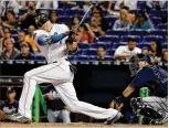  ?? MIKE EHRMANN / GETTY IMAGES ?? Giancarlo Stanton did not add to his season home- run total Friday night — he’s still at 59 — but he went 2 for 4 with a double, scored twice and drove in a run during the Marlins’ victory over the Braves in Miami.