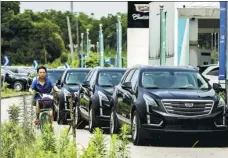  ?? QILAI SHEN / BLOOMBERG ?? General Motors’ Cadillacs park outside a car dealership in Shanghai. GM sold more than 4 million vehicles in China last year.