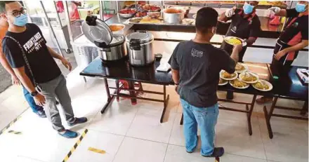  ?? (Foto Fathil Asri/bh) ?? Pelanggan beratur mengikut penjarakan sosial di sebuah kedai makan seperti SOP yang dikeluarka­n kerajaan akibat penularan wabak COVID-19.