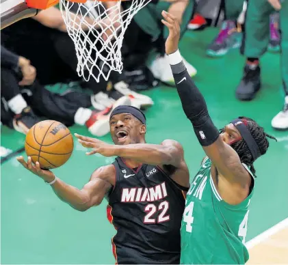  ?? Photo / AP ?? Miami Heat forward Jimmy Butler (left) shoots as Boston Celtic centre Robert Williams defends yesterday.