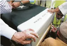  ?? Elizabeth Conley / Staff photograph­er ?? Volunteers move the coffin of Sabika Sheikh into Masjid Al-Sabireen for a funeral service on May 20 in Stafford. The 17-year-old Pakistani girl was slain at Santa Fe High School.