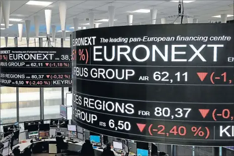  ?? Picture: REUTERS ?? STOCKING UP: Company stock price informatio­n are displayed on screens as they hang above the Paris stock exchange, operated by Euronext NV, in La Defense business district in Paris