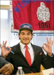  ?? RICHARD GRAULICH / THE PALM BEACH POST ?? Defensive end Dalton Hustad, signing with FAU, makes Owls signs at national signing day ceremonies Wednesday at Dwyer High.