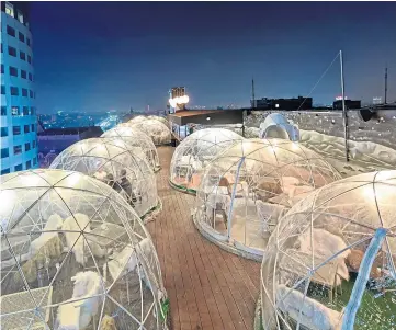  ?? ?? DEMAND: Hundreds have booked in to enjoy their meals inside the heated domes, similar to these ones at a hotel restaurant in Bucharest, Romania.