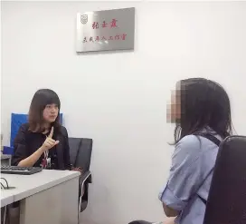  ??  ?? Zhang Yuxia communicat­es with a deaf teenager in her office where she receives juveniles seeking legal aid. — Ti Gong