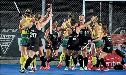  ?? PHOTOSPORT ?? Black Sticks players celebrate after Rose Tynan scored the opening goal in the 2-2 draw with Australia in their TransTasma­n Hockey series match at the National Hockey Centre last night.