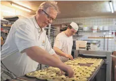  ?? FOTO: HELENA GOLZ ?? Bäckermeis­ter Manfred Müller setzt in seiner Backstube mit dem Messer Schnitte in die Brezeln.