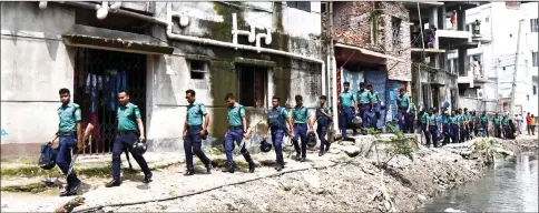  ??  ?? Bangladesh police walking near a building during a drug ops in Dhaka.