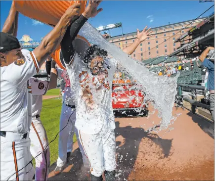  ?? Nick Wass The Associated Press ?? Orioles third baseman Rio Ruiz gets a post-game dousing Sunday after his two-out, two-run walkoff homer in the ninth inning rallied Baltimore to an 8-7 victory over the heavily favored Houston Astros. A day earlier, the struggling Orioles were routed by Houston 23-2.