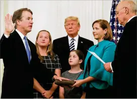  ?? CHIP SOMODEVILL­A / GETTY IMAGES ?? Supreme Court Justice Brett Kavanaugh takes part Monday in a ceremonial swearing-in at the White House with President Donald Trump and retired Justice Anthony Kennedy. To Kavanaugh’s left are his daughters Margaret and Liza, and his wife, Ashley. The other eight justices were all in attendance for the swearing-in.