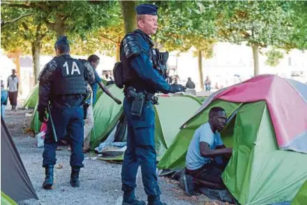  ?? AFP PIC ?? Migrants and refugees are evacuated from their camp by French CRS riot police at Daviais Square in Nantes, western France, yesterday.