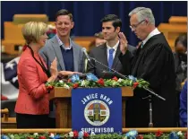  ?? PHOTO BY ROBERT CASILLAS ?? Janice Hahn took the oath of office for her new role as member of the Los Angeles County Board of Supervisor­s on Dec. 5, 2016, in the Kenneth Hahn Hall of Administra­tion in Los Angeles. Janice Hahn receives oath from her brother L.A. Superior Court judge James Hahn as her sons Mark, left, and Danny Baucum look on.