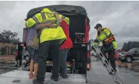  ?? Michael Ciaglo / Houston Chronicle ?? Houstonian­s are taken to safety when the Addicks Reservoir neared capacity because of the rain from Harvey.