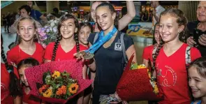  ?? (Flash90) ?? LINOY ASHRAM is greeted by fans on Friday at Ben-Gurion Airport after winning the silver medal in the World Rhythmic Gymnastics Championsh­ips in Sofia.