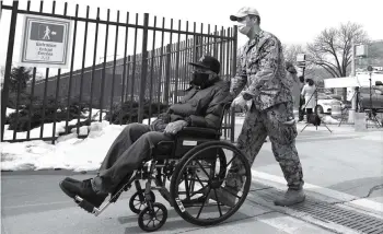  ?? MICHAEL M. SANTIAGO/GETTY IMAGES AMERIKA UTARA/AFP ?? SIAP SIAGA: Seorang tentara Garda Nasional membantu seseorang dengan kursi roda saat memasuki lokasi vaksinasi di York College pada Rabu (24/2) di kawasan Queens, New York City, Amerika Serikat.
