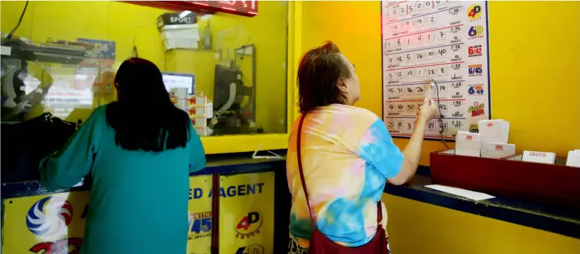  ?? PHOTOGRAPH BY ANALY LABOR FOR THE DAILY TRIBUNE ?? BETTORS play at a lotto outlet in Kamuning, Quezon City on Friday. Over P2.4 billion worth of jackpot prizes in 11 lotto games have been won since December 2023, according to data from the Philippine Charity Sweepstake­s Office.