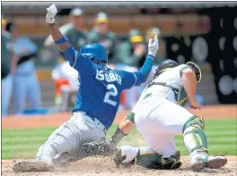  ?? THEARON W. HENDERSON — GETTY IMAGES ?? The Kansas City Royals’ Alcides Escobar gets tagged out sliding into home plate by A’s catcher Josh Phegley in the fourth inning. The Royals won 2-0at the Coliseum.