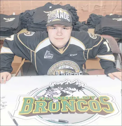  ?? MITCH MACDONALD/THE GUARDIAN ?? Charlottet­own Islanders volunteer Jayden Morrison shows the poster in support of the Humboldt Broncos that was signed by fans of both the Islanders and Halifax Mooseheads during last night’s playoff game. Both teams put aside their rivalries prior to...