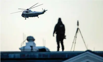  ?? Photograph: Shawn Thew/EPA ?? A Secret Service agent on the roof of the White House watches Donald Trump’s Marine One helicopter leave for the inaugurati­on of Joe Biden.