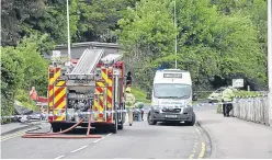  ??  ?? Emergency service workers at the scene of the two-vehicle crash.