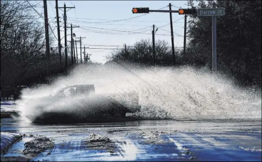  ?? Ronald W. Erdrich The Associated Press ?? A truck sends a wake of snowmelt into the air Friday in Abilene, Texas. A warm-up in Texas was expected to last several days.